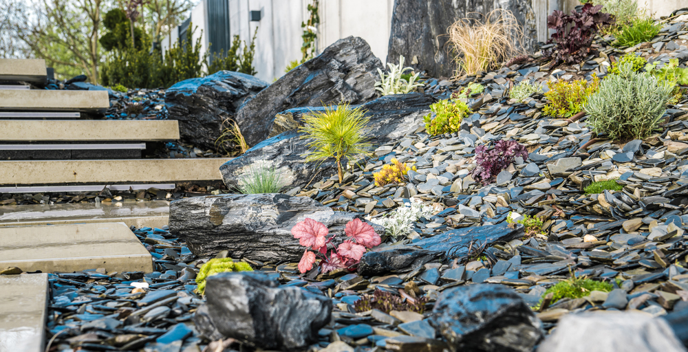 moderná skalka na svahu s kameňmi a okrasnými rastlinami ako nápady na skalky do modernej záhrady