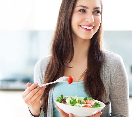 Usmievavá žena jediaca čerstvý zeleninový šalát