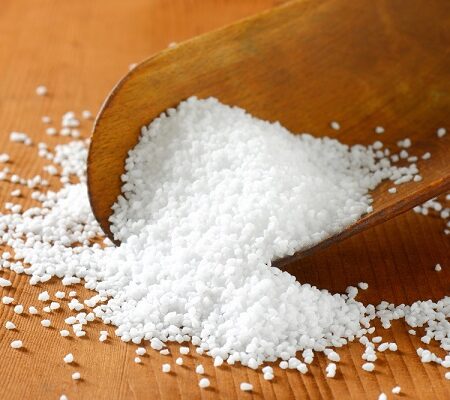Epsomská soľ na drevenej lopatke rozptýlená po stole.