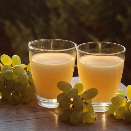 Ako spoznať pravý burčiak: Na čo si dať pozor pri výbere. Dva poháre na stole spolu z hroznom.