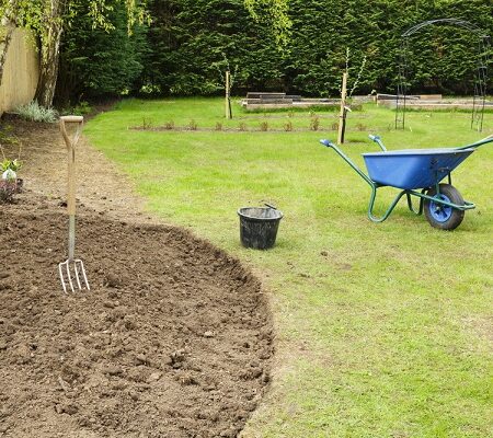Príprava záhrady na novú sezónu - upravený trávnik, čerstvo prekopaná pôda a záhradné náradie.