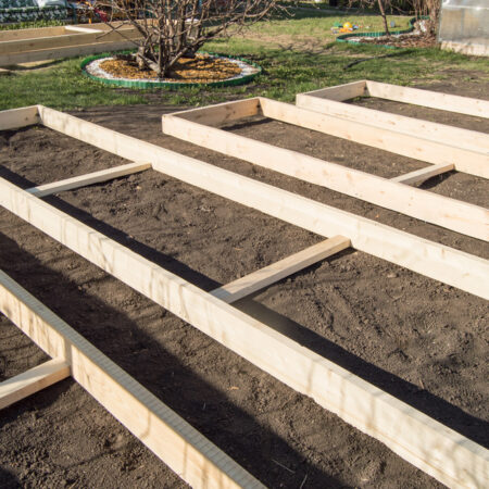 Vyvýšený drevený záhradný záhon pripravený na výsadbu na jar