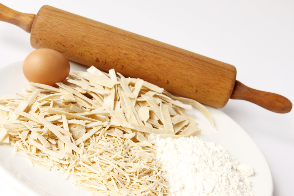 Domáce rezance na tanieri s múkou, vajíčkom a dreveným valčekom