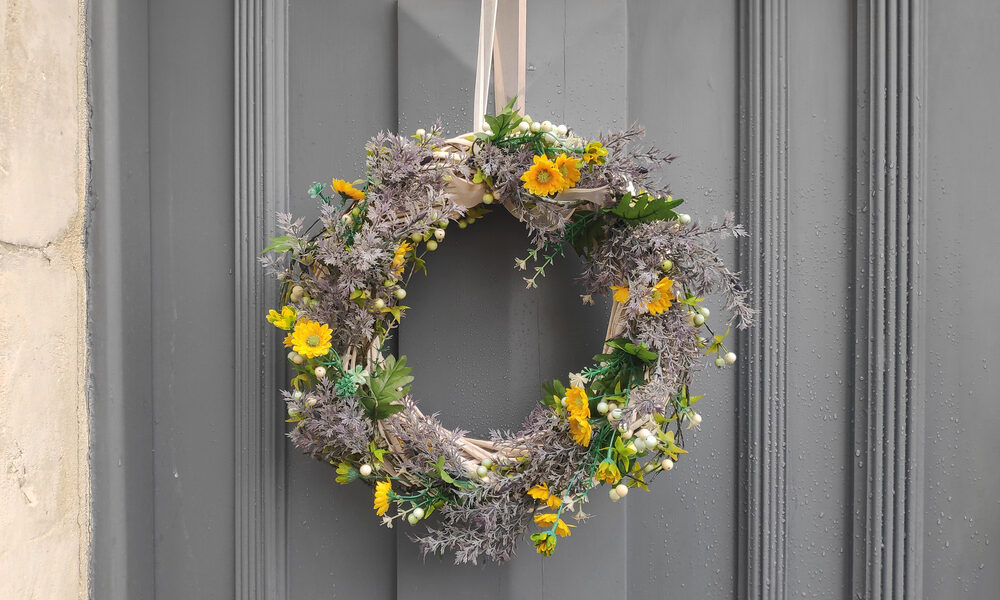 Tipy na jarné vence, Jarný veniec z prírodných vetvičiek a žltých kvetov zavesený na sivých vchodových dverách
