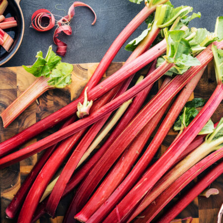 Čerstvé stonky rebarbory na drevenej doske – surovina známa pre rebarbora a jej účinky na zdravie